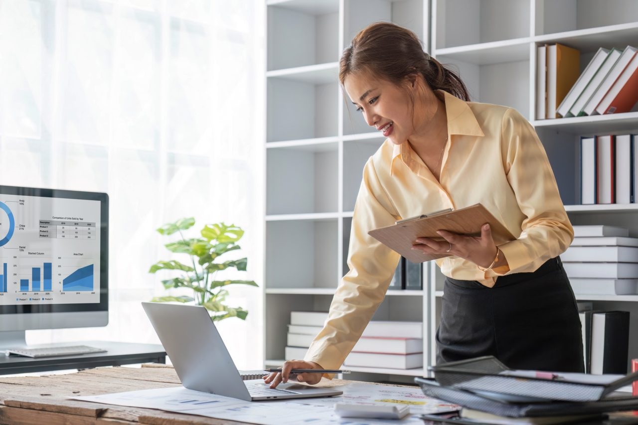 excited-business-asian-woman-sitting-at-table-with-laptop-and-celebrating-success.jpg